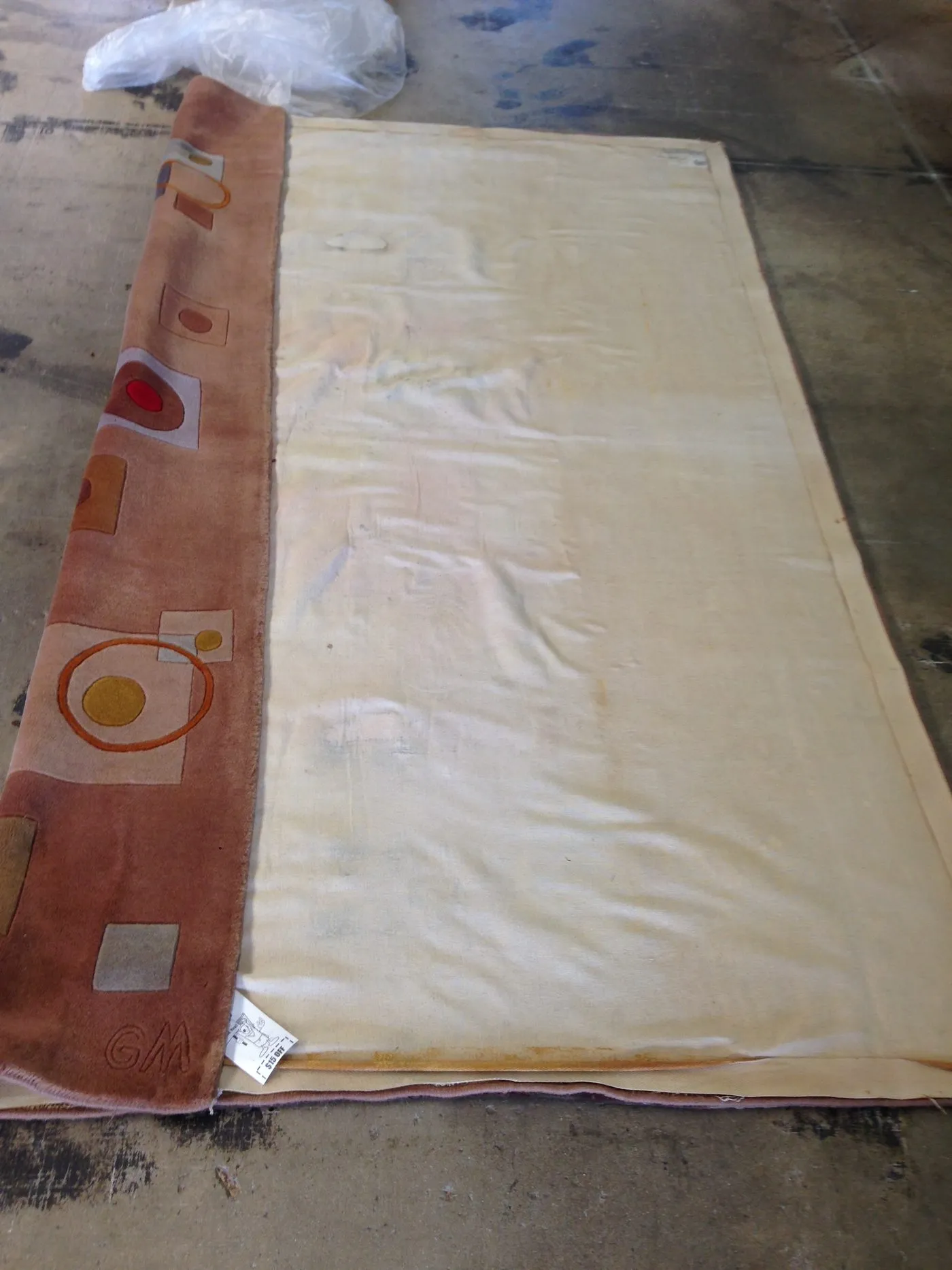 Rolled rug showing its back weave during inspection