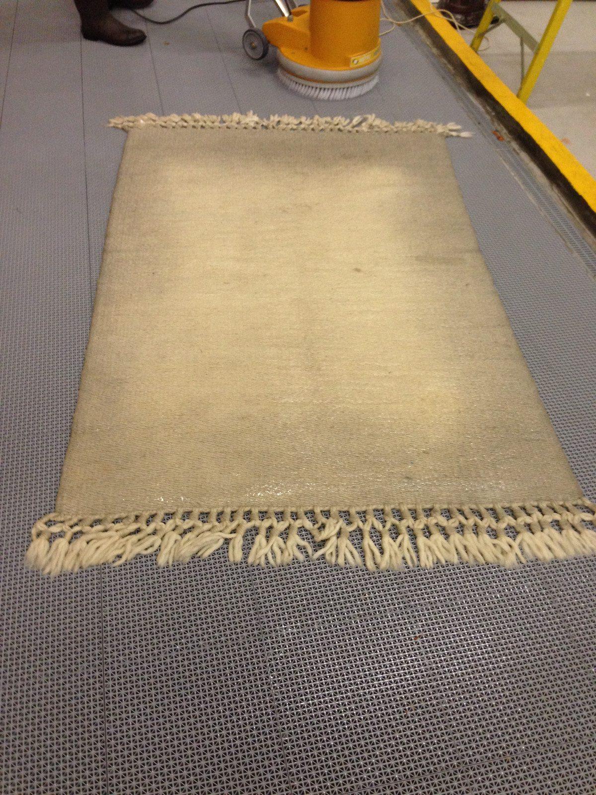Soiled beige flatweave rug before washing